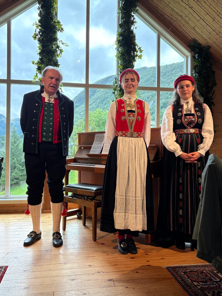 The owner and two young ladies dressed in traditional Norwegian clothes